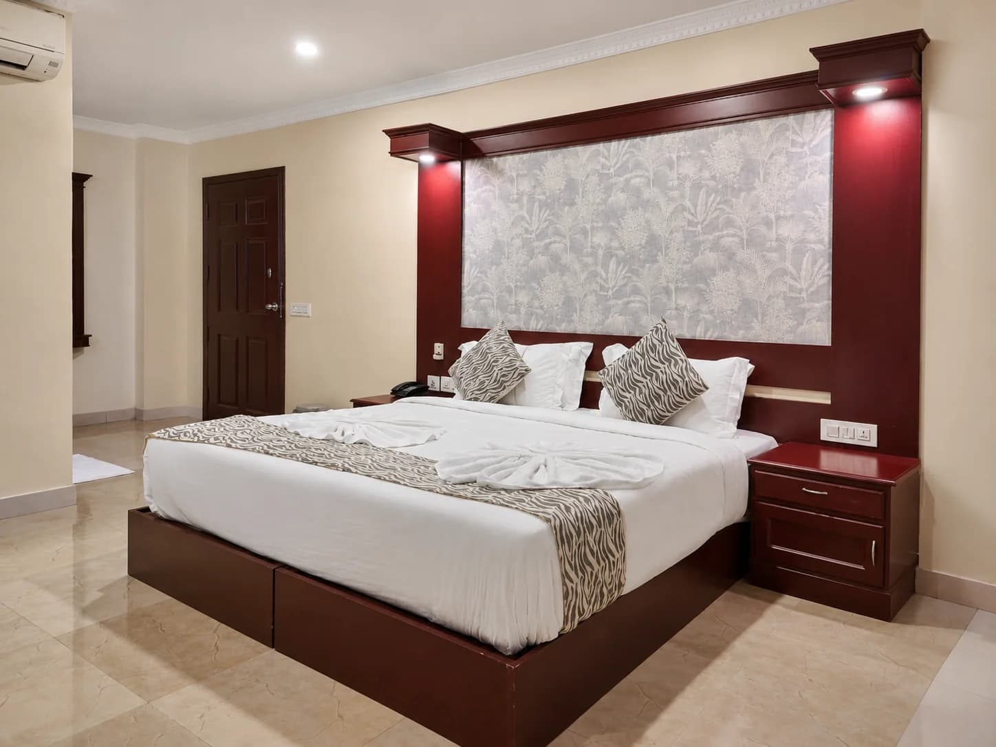 A guest room with a double bed and carved headboard
